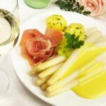Weißer Spargel mit Schinken und Kartoffeln und dazu ein Glas Weißwein