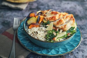 Herbstliche Harvest Chicken Bowl mit Wildreis, gegrilltem Hähnchen, geröstetem Gemüse und Grünkohl.